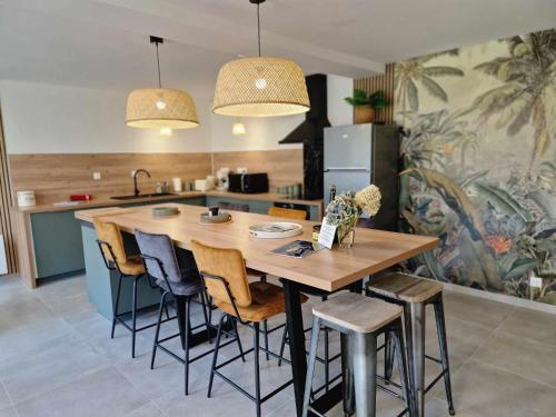 une cuisine avec une grande table et des chaises en bois dans l'établissement La Maison Entre Terre & Mer, à Gatteville-le-Phare