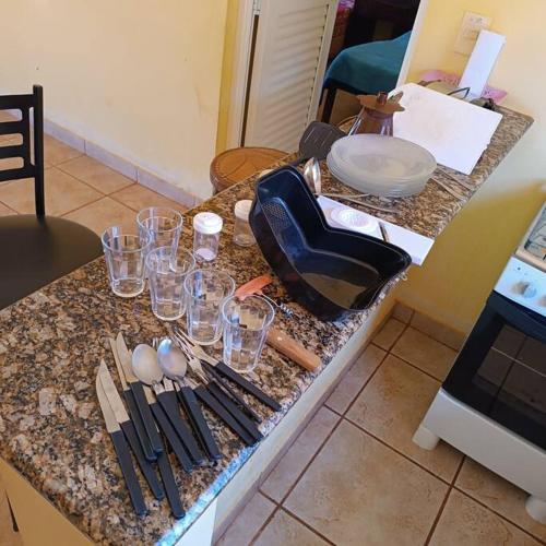 un bancone della cucina con bicchieri e utensili. di Chalés Confort 2 a Pimenta