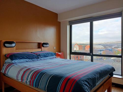 una camera da letto con un letto e una grande finestra di Belfast International Youth Hostel a Belfast