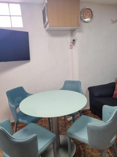 a meeting room with a white table and chairs at Cozy rooms in terraced house in Fuengirola