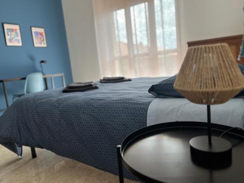 a bedroom with a bed and a table with a lamp at Casa Marconi - City Center in Bra