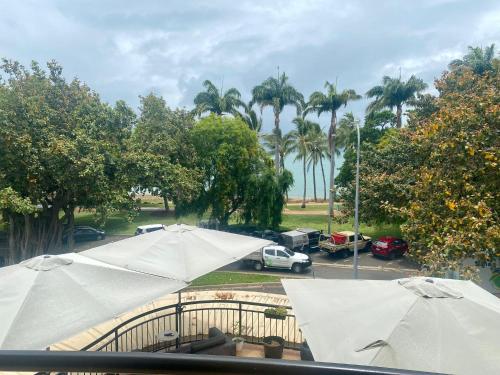 a group of umbrellas in a parking lot with palm trees at The Strand u15 in Townsville