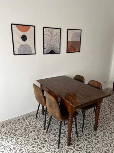 a dining room table with chairs and pictures on the wall at Casa Marconi - City Center in Bra