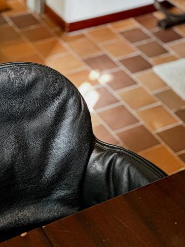 a black leather chair sitting on top of a table at Mina Suites in Cervia