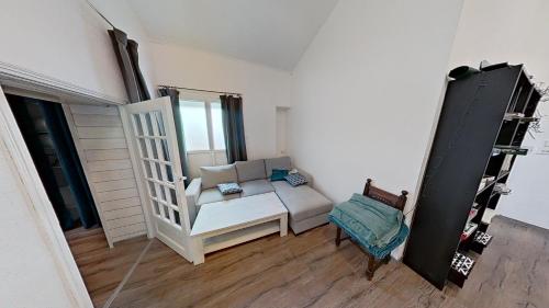 un salon avec un canapé et une chaise dans l'établissement Villa de Prestige à 400m de la plage Prestige CAMIMAX à 400m de la plage, à La Faute-sur-Mer