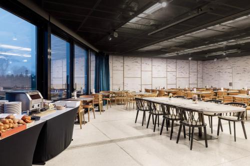 a large room with tables and chairs and windows at Marine Hotel by Zdrojowa in Kołobrzeg