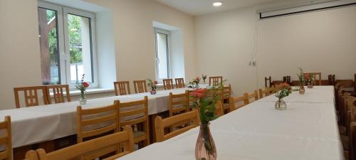 a conference room with a long table with flowers in a vase at Turistická Ubytovňa Zádiel - Turistaszálló Szádelő in Zádiel