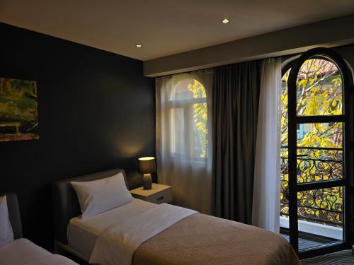 a bedroom with two beds and a window at Silver 39 Corner Hotel in Tbilisi City