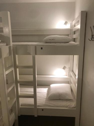 a white bunk bed with two white pillows on it at Hostel Dalagatan in Stockholm