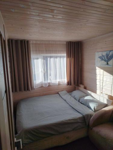 a bed in a small room with a window at Чан-садиба Гуцульська пісня in Mykulychyn