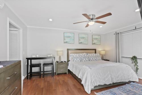 a bedroom with a bed and a desk with a ceiling fan at 4br Private Guest Suite Pool Pga Beaches in Palm Beach Gardens