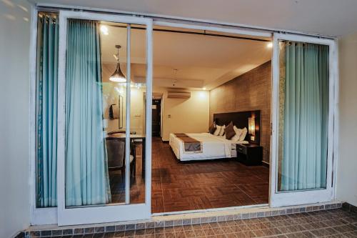 a bedroom with a bed and a large sliding glass door at Avoki Resorts in Trivandrum