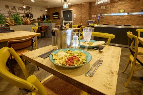a table with a bowl of food and a plate of pasta at Holiday Inn - the niu, Loom Manchester North by IHG in Manchester