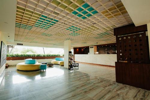 a lobby with two couches and a table and chairs at Avoki Resorts in Trivandrum