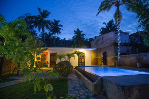 a house with a swimming pool in the yard at Saku Residence in Unawatuna