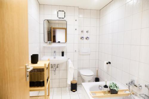 ein weißes Badezimmer mit Waschbecken und Toilette in der Unterkunft MA Home - Ferienwohnung in Günzburg in Günzburg