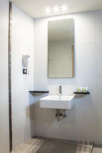a bathroom with a sink and a mirror at Anemos Rooms & Apartments in Nafplio