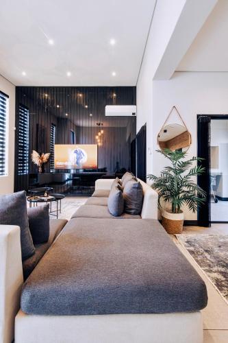 a living room with a large couch in front of a tv at Phoenix Home in Cape Town