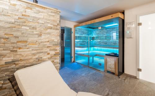 a room with a swimming pool and a stone wall at Ferienwohnungen Appartements Bergwald in Scheidegg