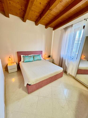 a bedroom with a bed and a large window at Corvina Suite in Costermano sul Garda