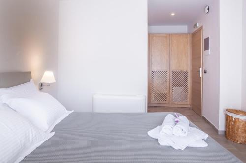 a bedroom with a bed with towels on it at Anemos Rooms & Apartments in Nafplio