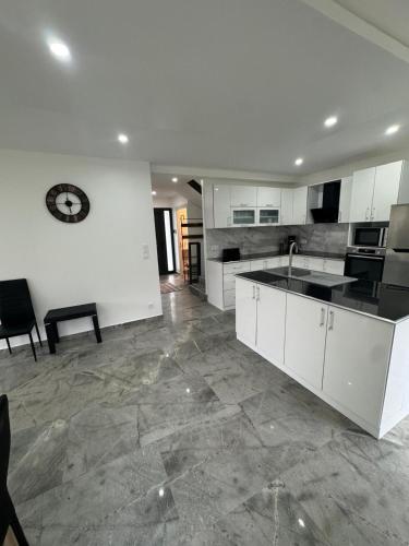 une grande cuisine avec des placards blancs et un évier dans l'établissement Maison Familiale 8 personne, à Esvres