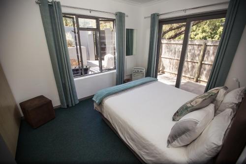 a bedroom with a bed and a large window at Chapman's Peak Bed and Breakfast in Hout Bay