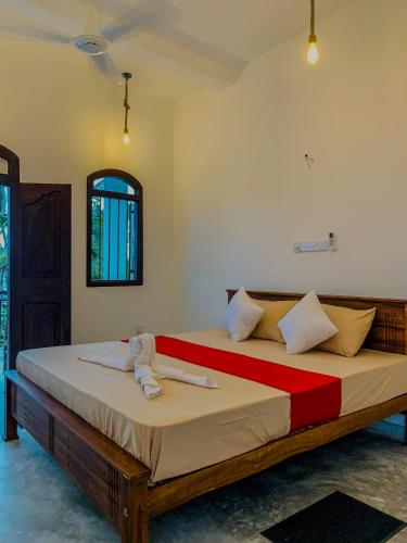 a bedroom with a bed with a red and white blanket at Surf View Point Ahangama in Ahangama