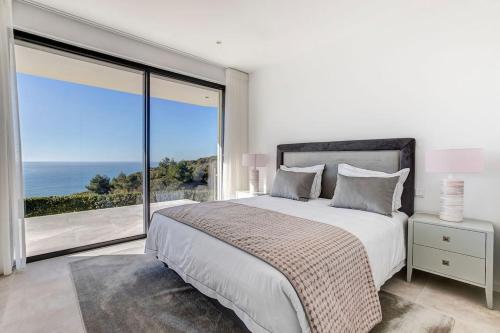 a bedroom with a large bed and a large window at Villa Centeanes - Luxury villa in Carvoeiro