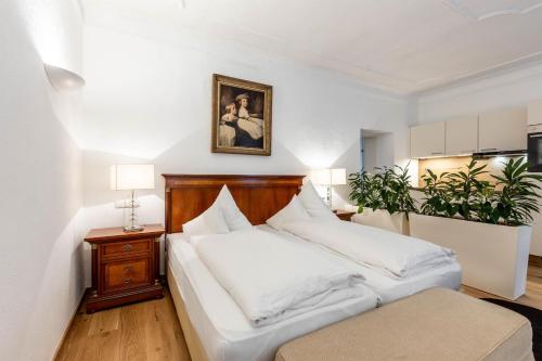 a bedroom with two beds and a picture on the wall at Apartments am Schloss Mühldorf in Feldkirchen an der Donau