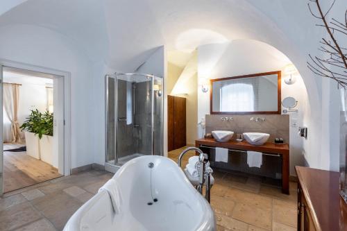 a bathroom with a tub and a shower and a sink at Apartments am Schloss Mühldorf in Feldkirchen an der Donau