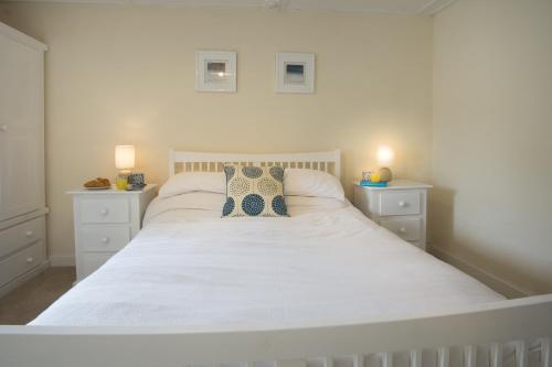 a white bed with two pillows on it in a bedroom at Ellesmere New Quay in New Quay