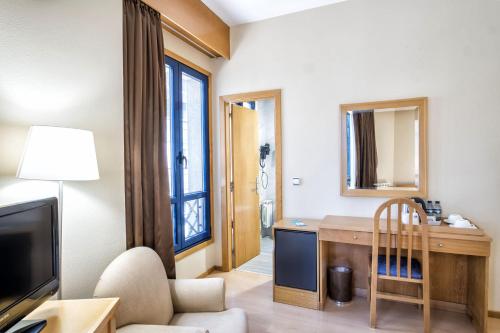 a living room with a desk and a television at Hotel Alda Castelao in Vilagarcia de Arousa