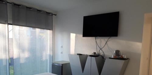 a living room with a flat screen tv on a wall at Love Room Glamour in Tremblay En France
