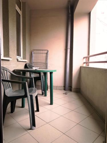 a green table and a chair on a balcony at Exclusive Skopje Apartments in Skopje