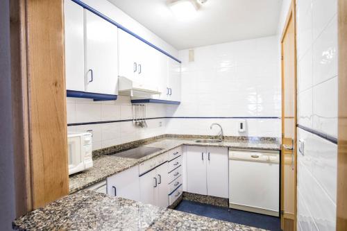 a kitchen with white cabinets and a sink at Hotel Alda Castelao in Vilagarcia de Arousa