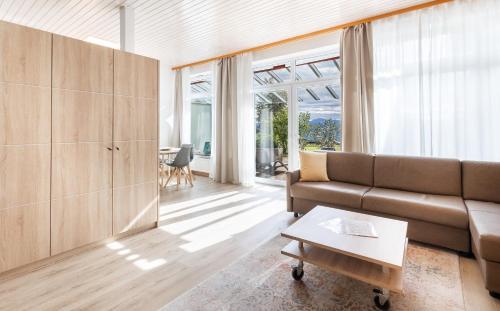 a living room with a couch and a table at Bergwald Panorama Suiten in Scheidegg