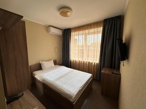 a small bedroom with a bed and a window at Yavir in Poltava