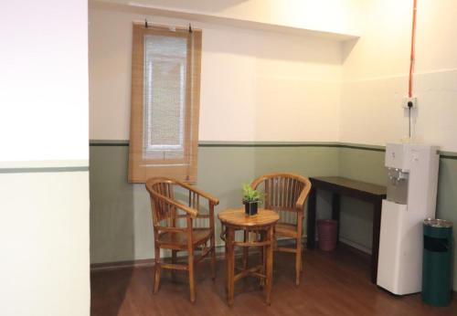 a kitchen with two chairs and a table and a refrigerator at Room V Kluang Parade By SECOM in Kluang