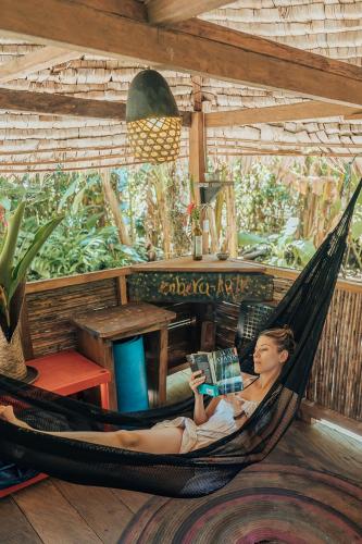 a woman sitting in a hammock reading a book at Poleo in Arusí