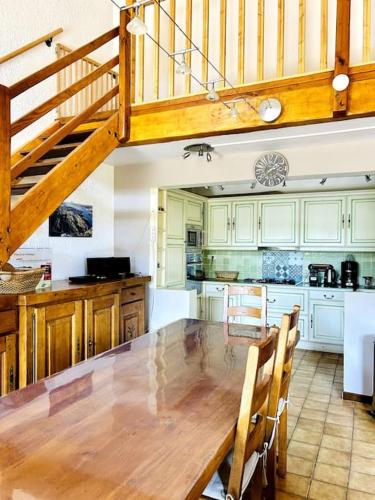une grande cuisine avec une table en bois et un escalier dans l'établissement Maison Parc du Verdon - Clim & Terrasse ombragée, aux Salles-sur-Verdon