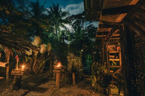 a garden at night with lights and palm trees at Poleo in Arusí