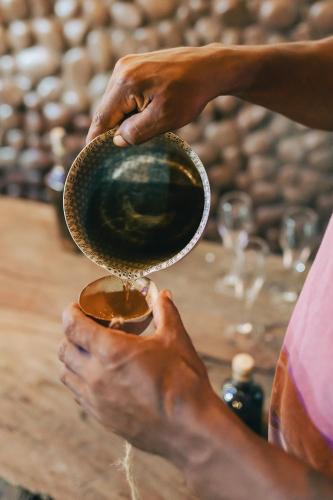 a person is pouring liquid into a bowl at Poleo in Arusí