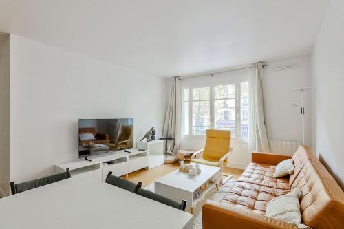 un salon avec un canapé et une télévision dans l'établissement Stunning 2BR Flat near Charonne metro station, à Paris