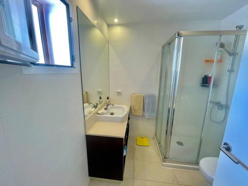 een witte badkamer met een wastafel en een douche bij Suite with views of son bou beach in Son Bou