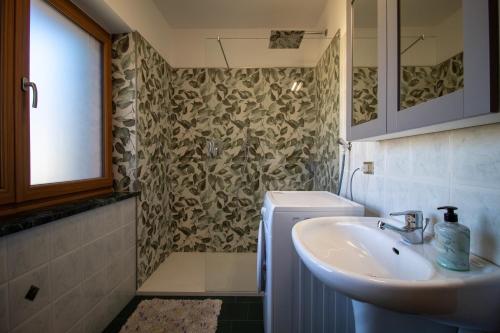 a bathroom with a sink and a toilet and a mirror at Villa Maria - Appartamento vista montagna in Moena