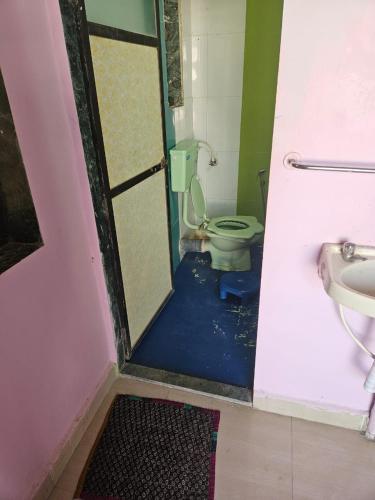 a bathroom with a toilet and a sink at Advait Holiday Home in Nagaon