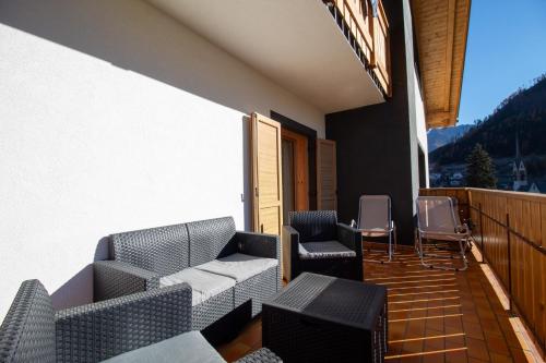 a balcony with couches and chairs on a building at Villa Maria - Appartamento vista montagna in Moena