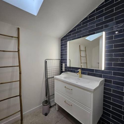 une salle de bain avec un lavabo blanc et un miroir dans l'établissement La Litoise, à Lit-et-Mixe