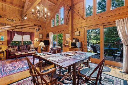 a dining room and living room with a table and chairs at Lakefront Log Cabin on 2 acres in Washington